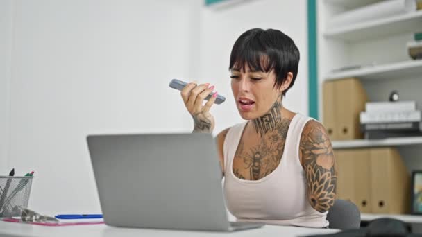 西班牙裔妇女 被截肢的女商人 在办公室里用笔记本电脑用智能手机传送语音信息 — 图库视频影像