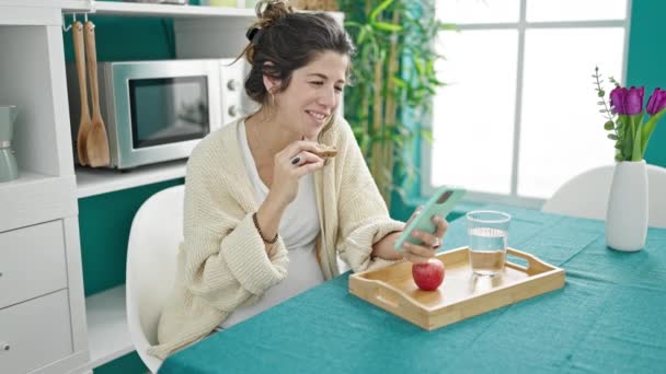 Mujer Embarazada Joven Desayunando Viendo Vídeo Teléfono Inteligente Comedor — Vídeo de stock