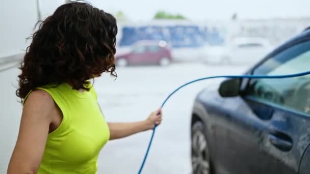 Mulher Hispânica Meia Idade Lavando Carro Com Arruela Pressão Estação — Vídeo de Stock