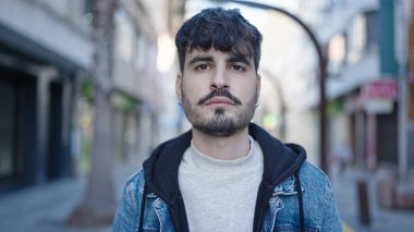 Sokakta ciddi bir ifadeyle duran İspanyol genç adam.