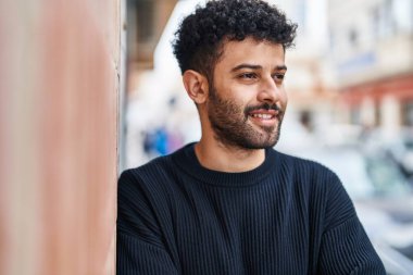 Young arab man smiling confident standing at street