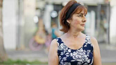 Middle age woman looking to the side with serious expression at street