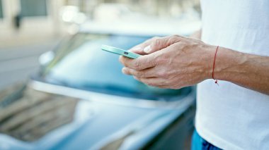 Sokakta akıllı telefon kullanan genç bir İspanyol.