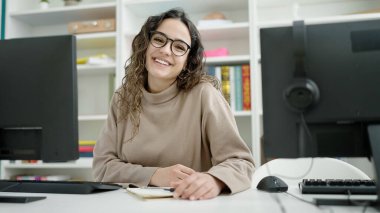 Kütüphanede bilgisayar kullanan güzel İspanyol bir kız öğrenci.