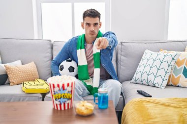 Yakışıklı İspanyol adam topu tutuyor kamerayı işaret eden bir takım ve sen kendine güvenen ciddi görünüyorsun. 