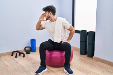 Sakallı İspanyol bir adam yoga odasında pilatese oturmuş el pençe divan durup bağırıyor. iletişim konsepti. 