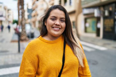 Young beautiful plus size woman smiling confident standing at street