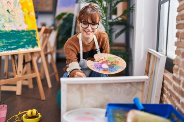 Young woman artist smiling confident drawing at art studio