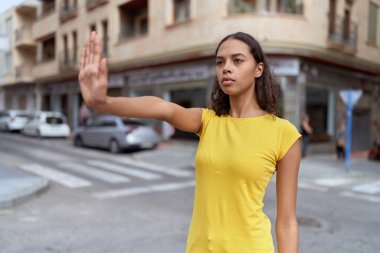 Young african american woman doing stop gesture with hand at street