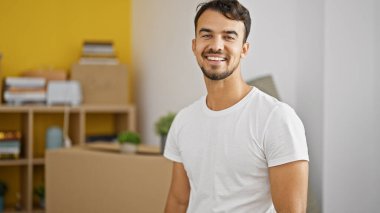 Yeni evinde kendine güvenen İspanyol bir adam gülümsüyor.