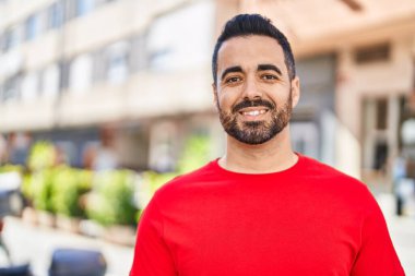 Sokakta kendinden emin gülümseyen İspanyol genç adam.