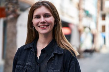 Sokakta kendine güvenen genç sarışın kadın gülümsüyor