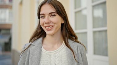 Sokakta kendinden emin gülümseyen genç İspanyol kadın.