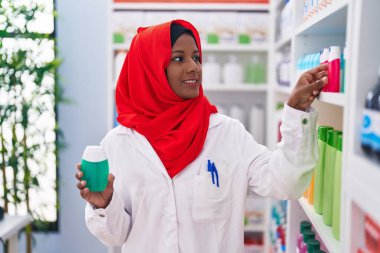 Eczanede diş macunu şişesi tutan güzel bir kadın eczacı.