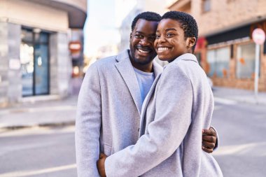 Man and woman couple hugging each other standing at street