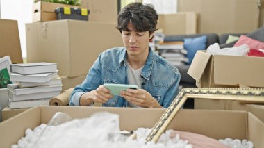 Yeni evimizde yerde oturmuş video oyunu oynayan İspanyol genç adam.