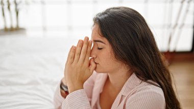 Genç, güzel İspanyol bir kadın yatak odasında dua ediyor.