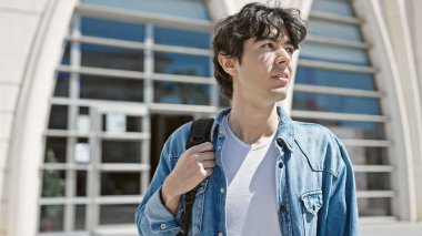 Üniversitede rahat bir ifadeyle duran genç İspanyol öğrenci.