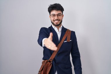 Sakallı, iş kıyafetleri giymiş, dostane bir şekilde el sıkışarak selamlaşan İspanyol bir adam. başarılı iş. 