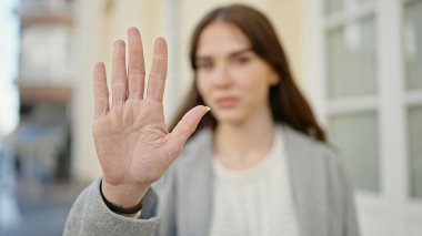 Genç İspanyol kadın sokakta el hareketlerini durduruyor.