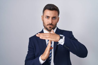 Yakışıklı İspanyol takım elbiseli ve kravatlı adam. Elleriyle jest yapıyor. Hayal kırıklığına uğramış ve ciddi bir yüz ifadesi var. 