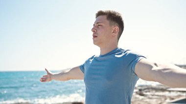 Genç İspanyol adam deniz kenarında nefes alıyor.