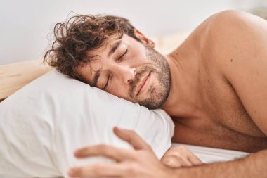 Young man lying on bed sleeping at bedroom