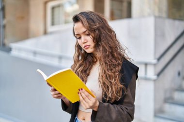 Sokakta kitap okuyan genç, güzel İspanyol kadın.