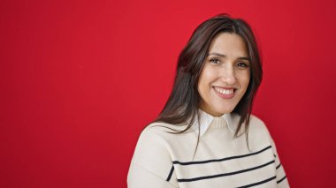 Genç ve güzel İspanyol kadın, kendine güvenen, izole kırmızı arka planda duran.