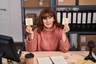 Orta yaşlı İspanyol kadın küçük işletmelerde çalışıyor. Mutlu ve hüzünlü duyguları var. Gülümsüyor ve başka tarafa bakıyor.. 