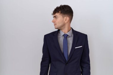 Genç İspanyol iş adamı takım elbise ve kravat takıyor. Tarafını arıyor, rahat poz veriyor. Kendine güvenen bir gülümsemesi var.. 