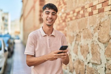 Sokakta akıllı telefon kullanan, kendine güvenen genç bir İspanyol.