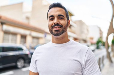 Sokakta kendinden emin gülümseyen İspanyol genç adam.