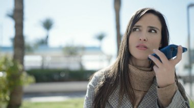 Güzel İspanyol kadın sokakta akıllı telefonuyla sesli mesaj yolluyor.