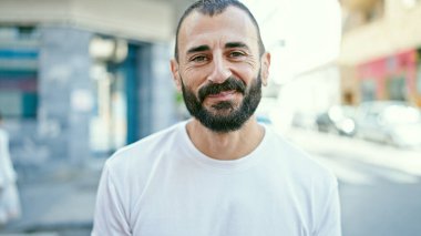 Sokakta kendinden emin gülümseyen İspanyol genç adam.