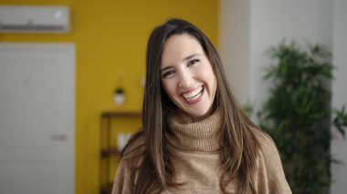 Güzel İspanyol kadın evde kendinden emin gülümsüyor.