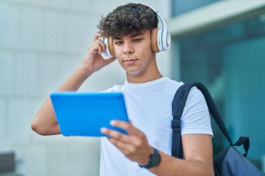 Genç İspanyol öğrenci üniversitede touchpad 'de video seyrediyor.