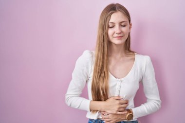 Mide hazımsızlığı, acı verici bir hastalık yüzünden pembe arka planda duran beyaz bir kadın. Ağrı kavramı. 