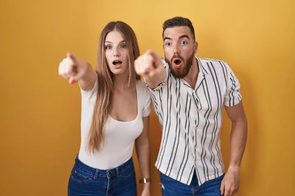 Young Couple Standing Yellow Background Pointing Finger Surprised Ahead Open — Stock Photo, Image