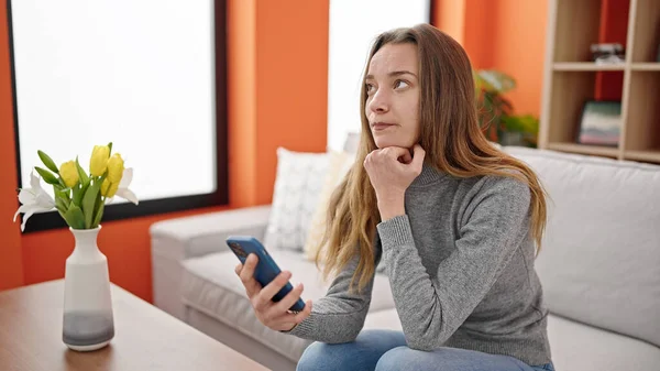 Young Caucasian Woman Using Smartphone Serious Expression Home — 图库照片