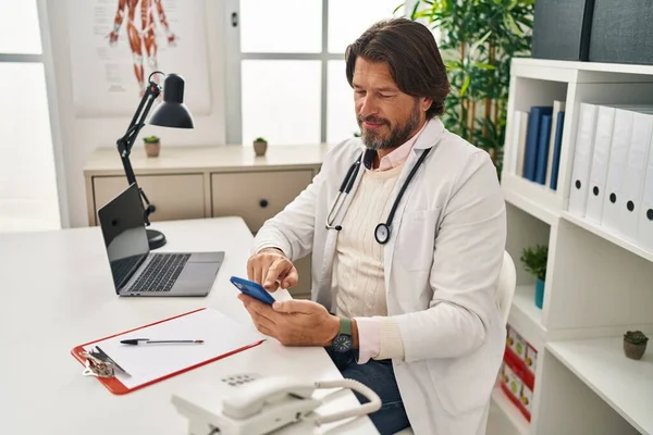 Middle Age Man Doctor Using Smartphone Working Clinic — Fotografia de Stock