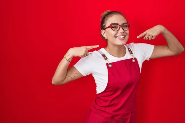 Mujer Hispana Joven Con Delantal Camarera Sobre Fondo Rojo Sonriendo —  Fotos de Stock