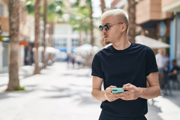 Stock image Young caucasian man using smartphone at street