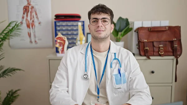 Młody Latynoski Mężczyzna Lekarz Uśmiecha Się Pewnie Klinice — Zdjęcie stockowe