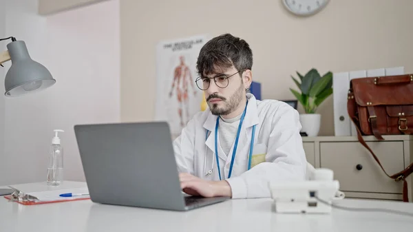 Young Hispanic Man Doctor Using Laptop Working Clinic — Stock fotografie