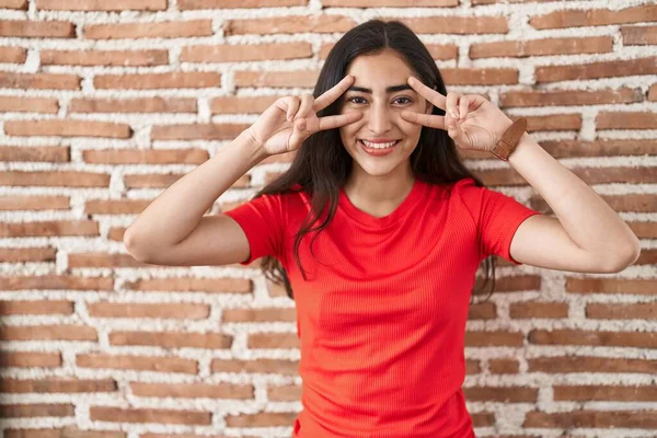 Junges Teenager Mädchen Steht Über Ziegelmauer Und Macht Friedenssymbol Mit — Stockfoto