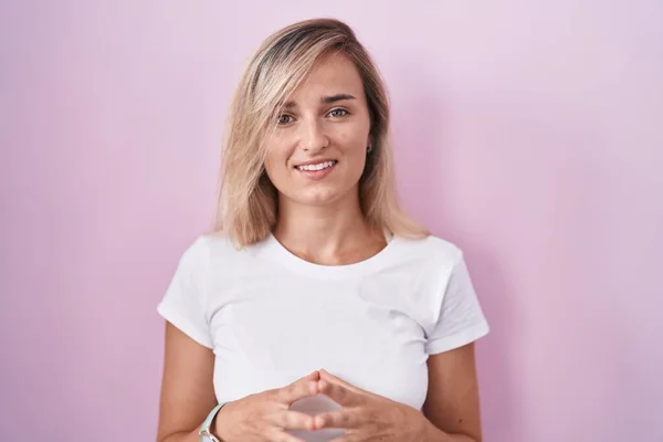 Young Blonde Woman Standing Pink Background Hands Together Fingers Crossed — Foto de Stock