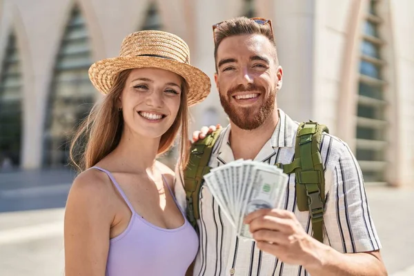 Young Tourist Couple Holding Dollars Banknotes Looking Positive Happy Standing — Stock Photo, Image