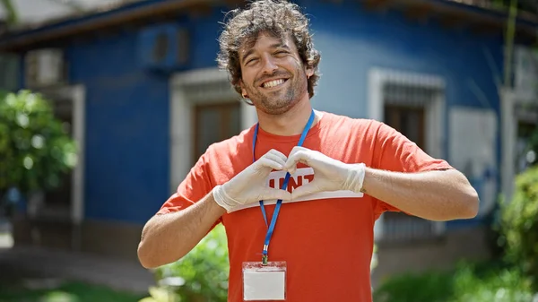 Jovem Ativista Hispânico Vestindo Uniforme Voluntário Fazendo Gesto Cardíaco Parque — Fotografia de Stock
