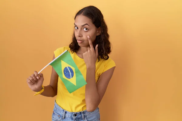 Молодая Латиноамериканка Держащая Бразильский Флаг Указывая Глаз Наблюдая Твоим Жестом — стоковое фото